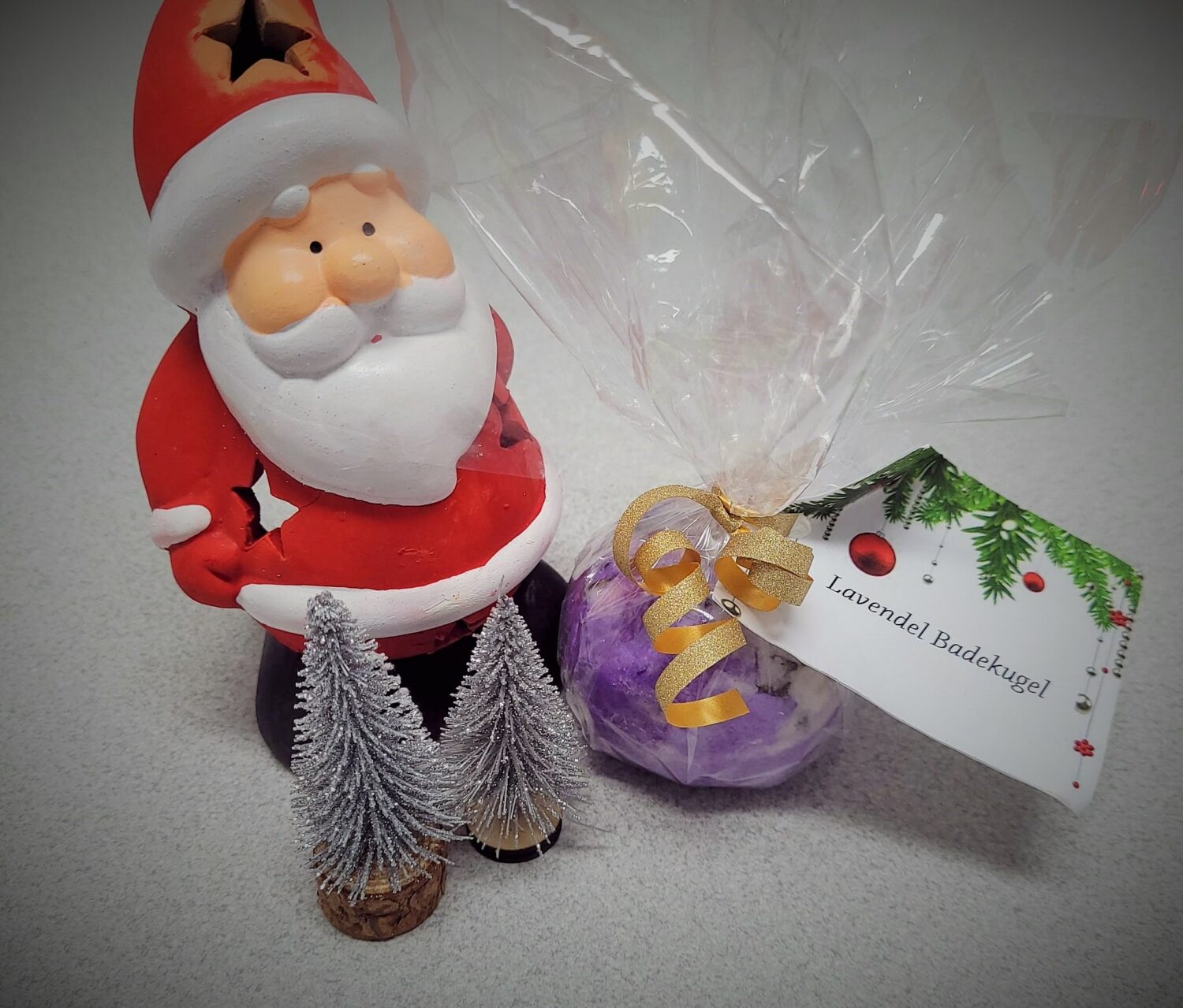 Eine Selbstgemachte Lavendel Bade Kugel liegt schön Verpackt neben einem Kleinem Weihnachtsmann